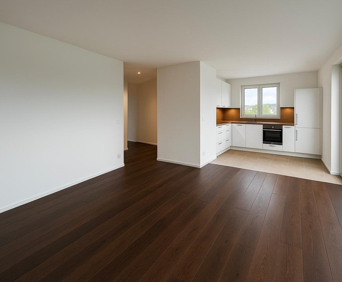 Wohn-Essbereich mit dunklem Parkett und offener Küche in Neubauwohnung Osnabrück